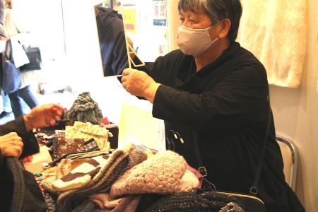 試着のお客さんに鏡を差し出す出店者の女性