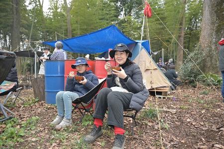 椅子に座って豚汁を飲む2人