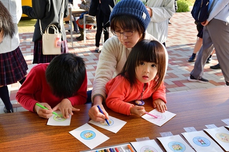 子どもたちが楽しそうに缶バッジ作りをしている