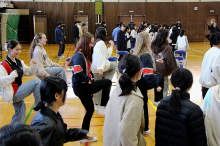 一緒にダンスを踊り交流を深める高校生と小学生