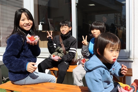 マルシェで購入したいちごを食べる子ども4人