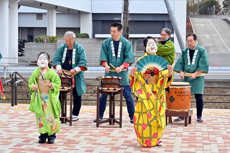 YOT-TOKO前のテラスで、重松流祭ばやしの披露とおかめの踊りが行われている場面。