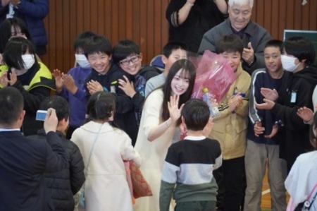 最後の見送りで児童たちが花道を作り、坂巻さんが子どもたちをハイタッチしている様子。児童も皆、笑顔。