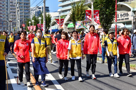 ゴールボール女子日本代表の選手4名が横一列になって歩いている、パレードの様子