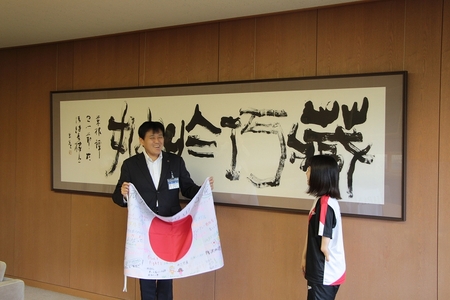 小野塚市長が西田選手に国旗を渡す